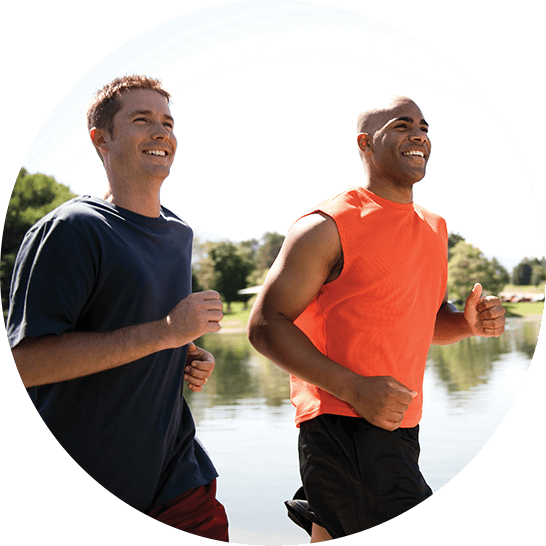 Two adult men running outdoors