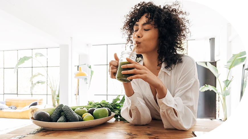 Woman sipping a green juice.